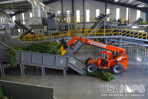 Growers are always reinvesting in their equipment to bring the best possible hops to consumers – pictured here is a brand new facility in its first harvest. This is a new system where large heaps of hops are loaded up and the bines get chopped into smaller pieces and the cones are stripped and separated from the leaves.